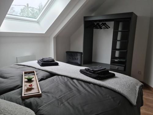 a bedroom with a bed with a tray with towels on it at Charmant gîte 80m² proche frontière belge, jardin privatif, terrasse, tout inclus, 2 chambres, WiFi - FR-1-510-133 in Sebourg