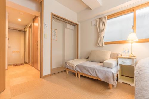 a bedroom with a bed and a window and a chair at Ken Hotel Tokyo Shinjuku in Tokyo