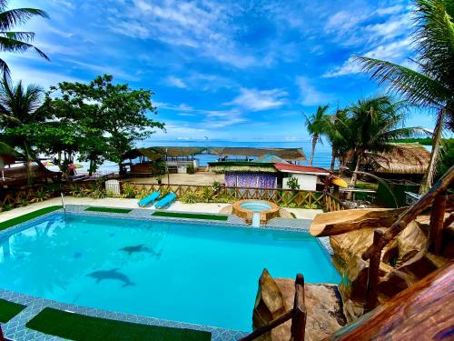 a swimming pool with a view of the ocean at Jala Beach Resort in Loay