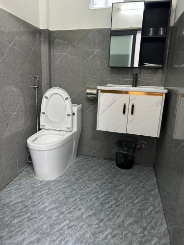 a bathroom with a toilet and a sink and a mirror at Hotel Hồng Cẩm in Trung An