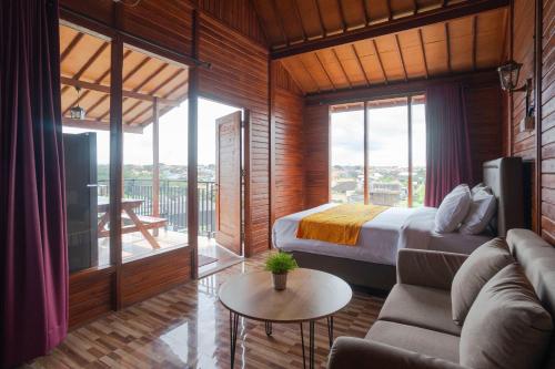 Un dormitorio con una cama y una sala de estar con un sofá. en Sky Apartments and Suites, en Canggu