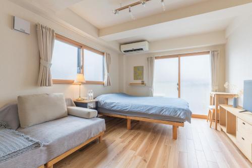 a bedroom with a bed and a couch at Ken Hotel Tokyo Shinjuku in Tokyo