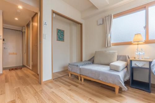 a living room with a chair and a window at Ken Hotel Tokyo Shinjuku in Tokyo