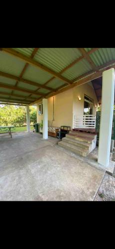 a building with a porch and stairs and a bench at Bungalow Vaihere in Orufara