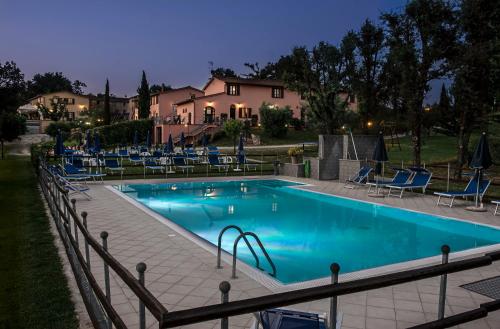 una piscina con sillas azules y una casa en Corte Tommasi Residence, en Orentano