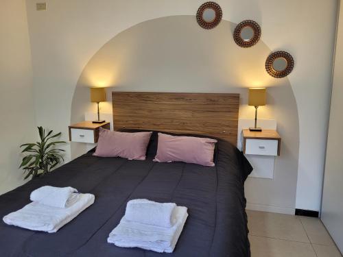 Un dormitorio con una cama grande con dos toallas encima. en Casa Rubí - Encantador apartamento en Mendoza - Cochera privada y seguridad permanente, en Guaymallén