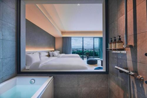 a large mirror in a bathroom with a bed and a tub at edit x seven FUJI GOTEMBA in Gotemba