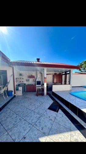 a large patio with a kitchen and a swimming pool at Recanto da paz in Matinhos