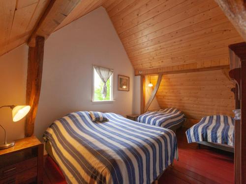 two beds in a room with wooden ceilings at Cozy Apartment in Enschede near Forest in Enschede