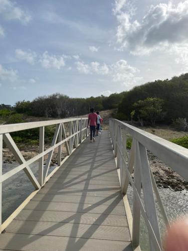 a group of people walking across a bridge at Hummingbird Villa in Saint Johnʼs