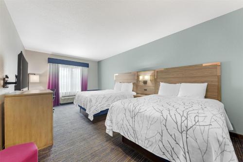 a hotel room with two beds and a flat screen tv at Best Western Plus San Antonio East Inn & Suites in San Antonio