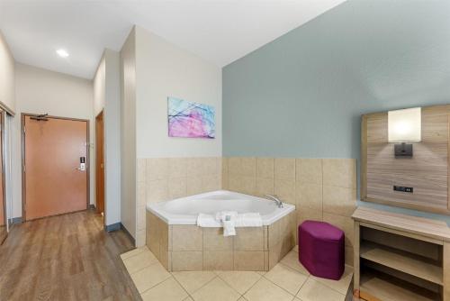 a bathroom with a bath tub and a purple stool at Best Western Plus San Antonio East Inn & Suites in San Antonio