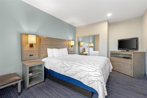 a hotel room with a bed and a flat screen tv at Best Western Plus San Antonio East Inn & Suites in San Antonio