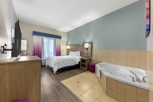a hotel room with a bed and a bath tub at Best Western Plus San Antonio East Inn & Suites in San Antonio