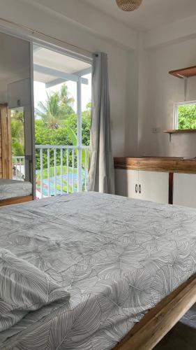 a large bed in a bedroom with a balcony at Padayon Island Stay in General Luna