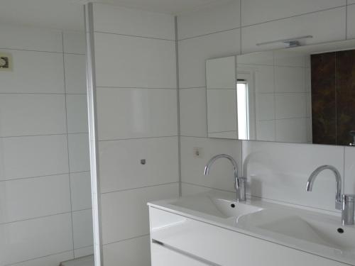 a white bathroom with a sink and a mirror at Holiday home with gas fireplace & bath in Bemelen