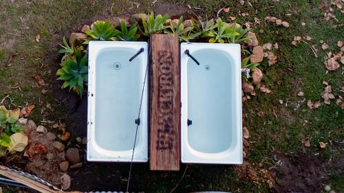 two white toilets sitting on the ground in the grass at Wallaby by Tiny Away in Thoopara