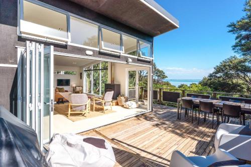 a house with a deck with a view of the ocean at Bella Vista Bliss in Waiheke Island