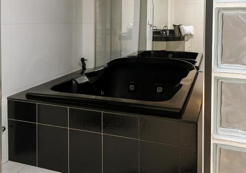 a bathroom with a black sink and a mirror at Apartamentos Porto Maravilha in Rio de Janeiro