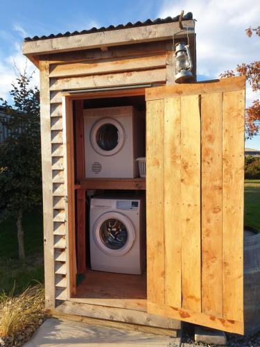 a washing machine in a wooden out house at Schist Rock Lodge in Omakau