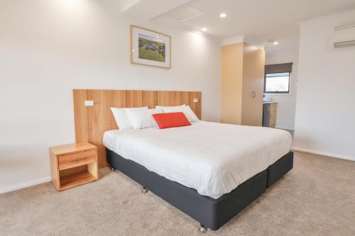 une chambre avec un grand lit avec un oreiller rouge dans l'établissement Robinvale Golf Club Resort, à Robinvale 