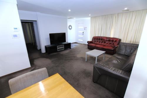 a living room with a couch and a television at Houses in Goulburn in Goulburn
