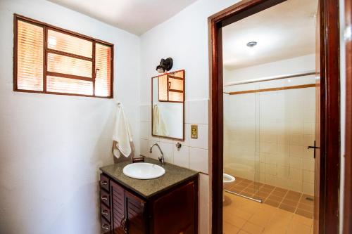 a bathroom with a sink and a shower at Hotel Fazenda Portal da Canastra in Zogaias