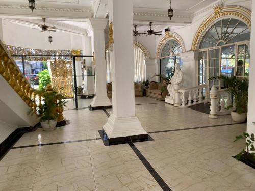 a lobby with columns and plants in a building at Le Hotel Hotel Phnom Penh in Phnom Penh
