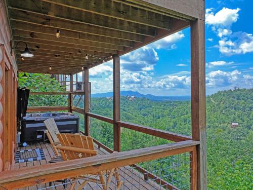 a view from the deck of a cabin with a table and chairs at WOW, that View! NEW Luxury Cabin - Hot Tub - Pool Access - Game Room in Sevierville
