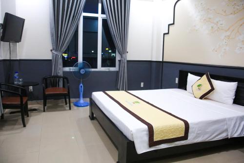 a bedroom with a bed and a table and a window at Khách sạn Đại An Ninh Bình in Ninh Binh