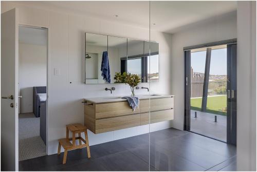 a bathroom with a sink and a mirror at Beach, Golf & Luxury! Sunrise to Sunset Views in Forster