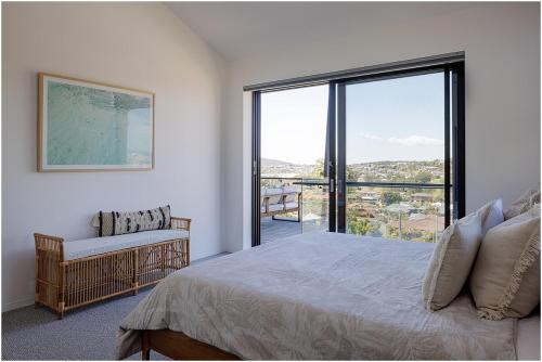 a bedroom with a bed and a large window at Beach, Golf & Luxury! Sunrise to Sunset Views in Forster