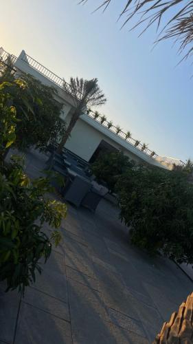 a white building with trees and bushes in front of it at Verdant gem in Bībīnagar