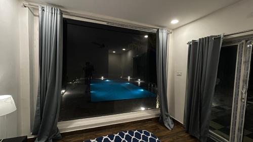 a view of a swimming pool through a window at Verdant gem in Bībīnagar