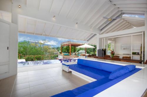 a large living room with a blue couch and a patio at Villa Nirvana - Villeta in Payandé
