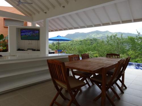 a dining room with a wooden table and chairs at Villa Nirvana - Villeta in Payandé