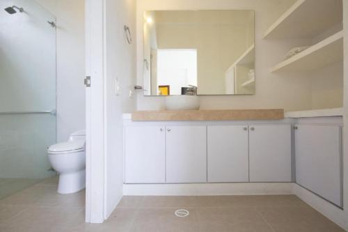 a bathroom with a toilet and a sink and a mirror at Villa Nirvana - Villeta in Payandé
