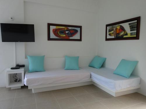 two beds in a room with blue pillows and a tv at Villa Nirvana - Villeta in Payandé