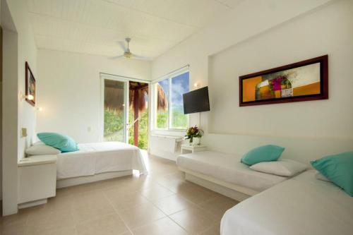a white room with two beds and a window at Villa Nirvana - Villeta in Payandé