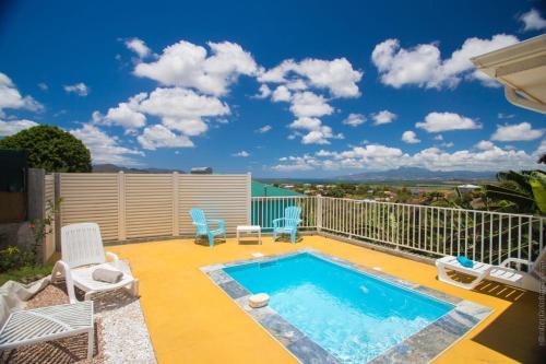 a patio with a swimming pool and chairs on a balcony at Les Villas Saint-Joseph in Rivière-Salée