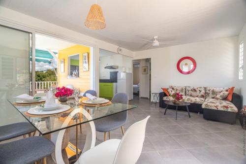a living room with a glass table and chairs at Les Villas Saint-Joseph in Rivière-Salée
