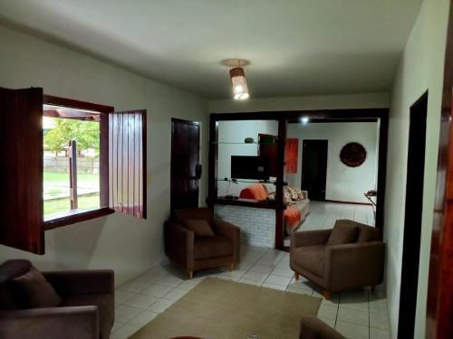 a living room with two chairs and a couch and a television at Casa Tropical in Marau