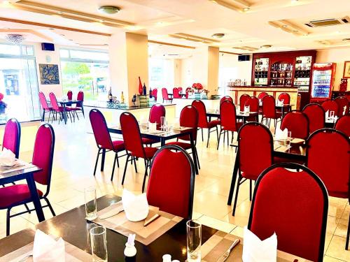 a restaurant with red chairs and tables and a bar at Chau Pho Hotel in Chau Doc