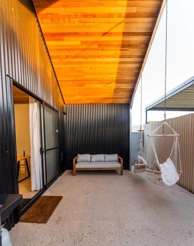 a room with a couch and a swing at The Salted Shed - 650m to beach in Seaford