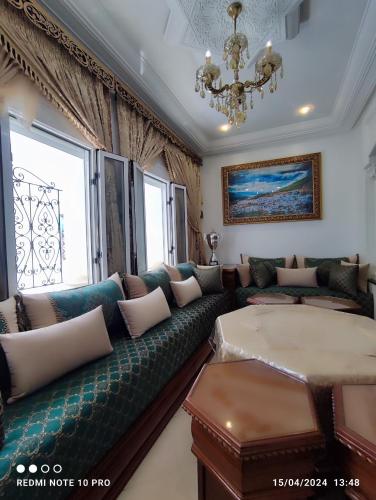 a living room with a couch and a chandelier at Dar NABIL in Chefchaouen