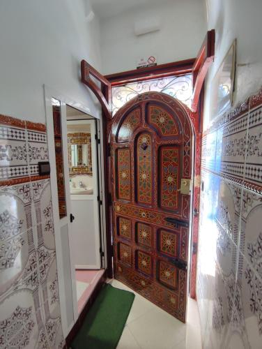 a wooden door in a room with a green floor at Dar NABIL in Chefchaouen