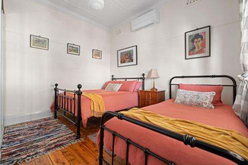 Dos camas en una habitación con paredes blancas. en Sweet Stewart - Walk to CBD Convenient & Cosy, en Bathurst