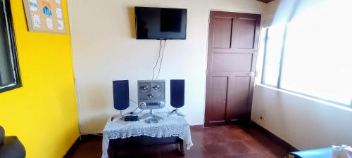a room with a table and a tv on a wall at Apartamentos CasaMJ Tunja Confort y Parqueadero in Tunja