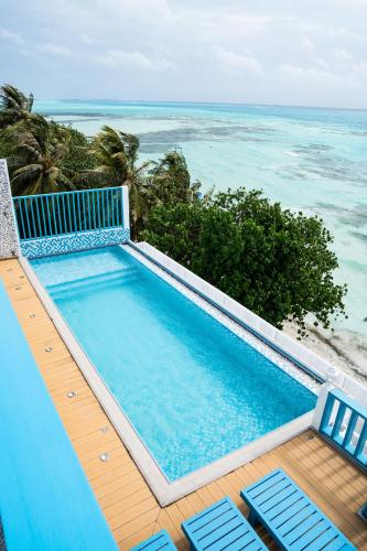 una piscina con 2 sillas y el océano en Endorphins Beach Villa, en Dhiffushi