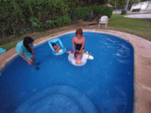 two women playing in a swimming pool with a child at Las mejores vacaciones en Paraíso Diamante in Gallinero